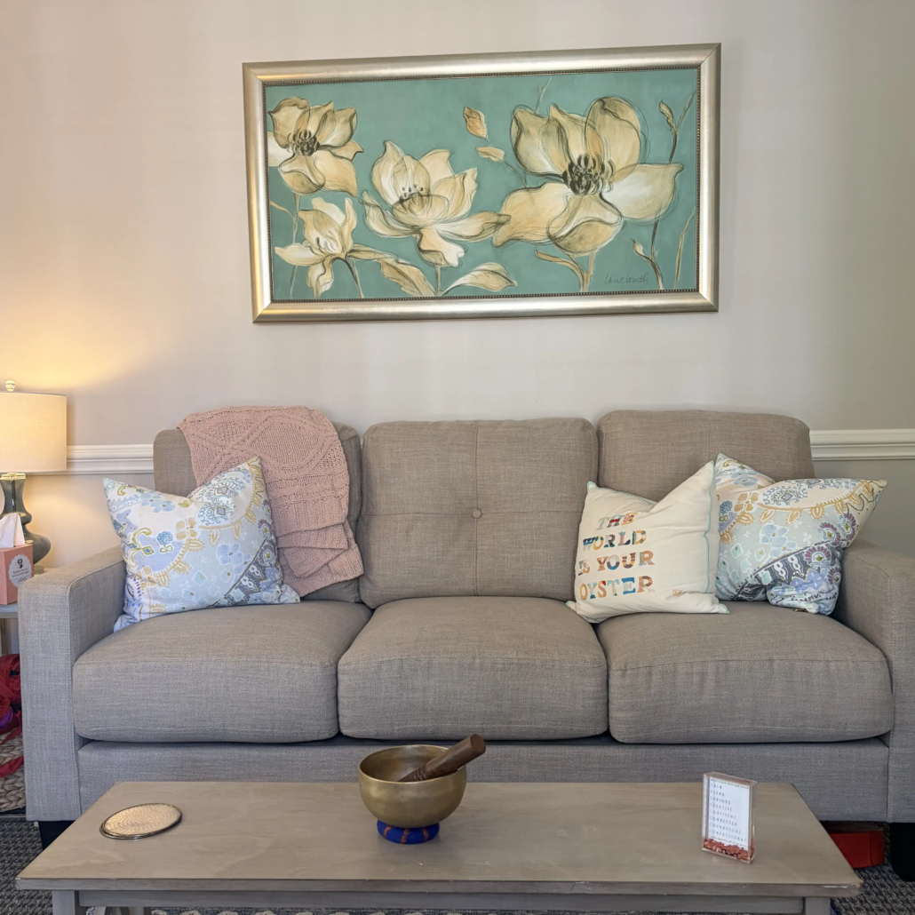 Amanda's Therapy Office Therapy space with couch, pillows, artwork, and welcoming decor for therapy clients